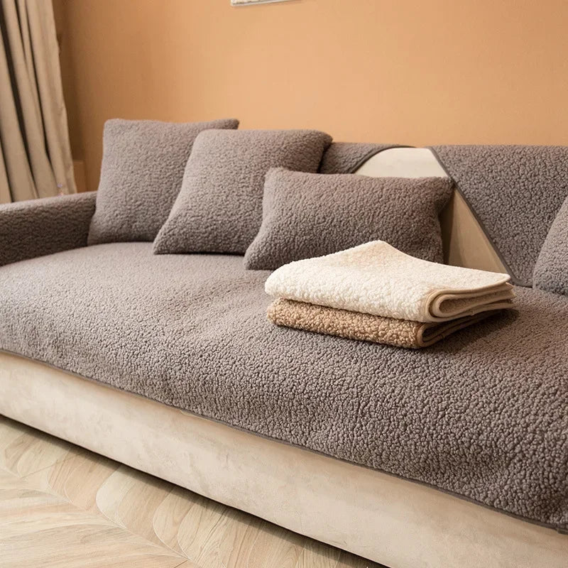 Couverture protection canapé gris en tissu doux avec coussins assortis et couvertures pliées beige et crème