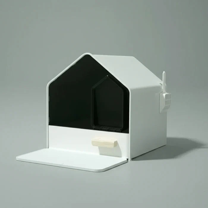 Litière design chat en forme de maison moderne avec pelle intégrée et surface blanche minimaliste